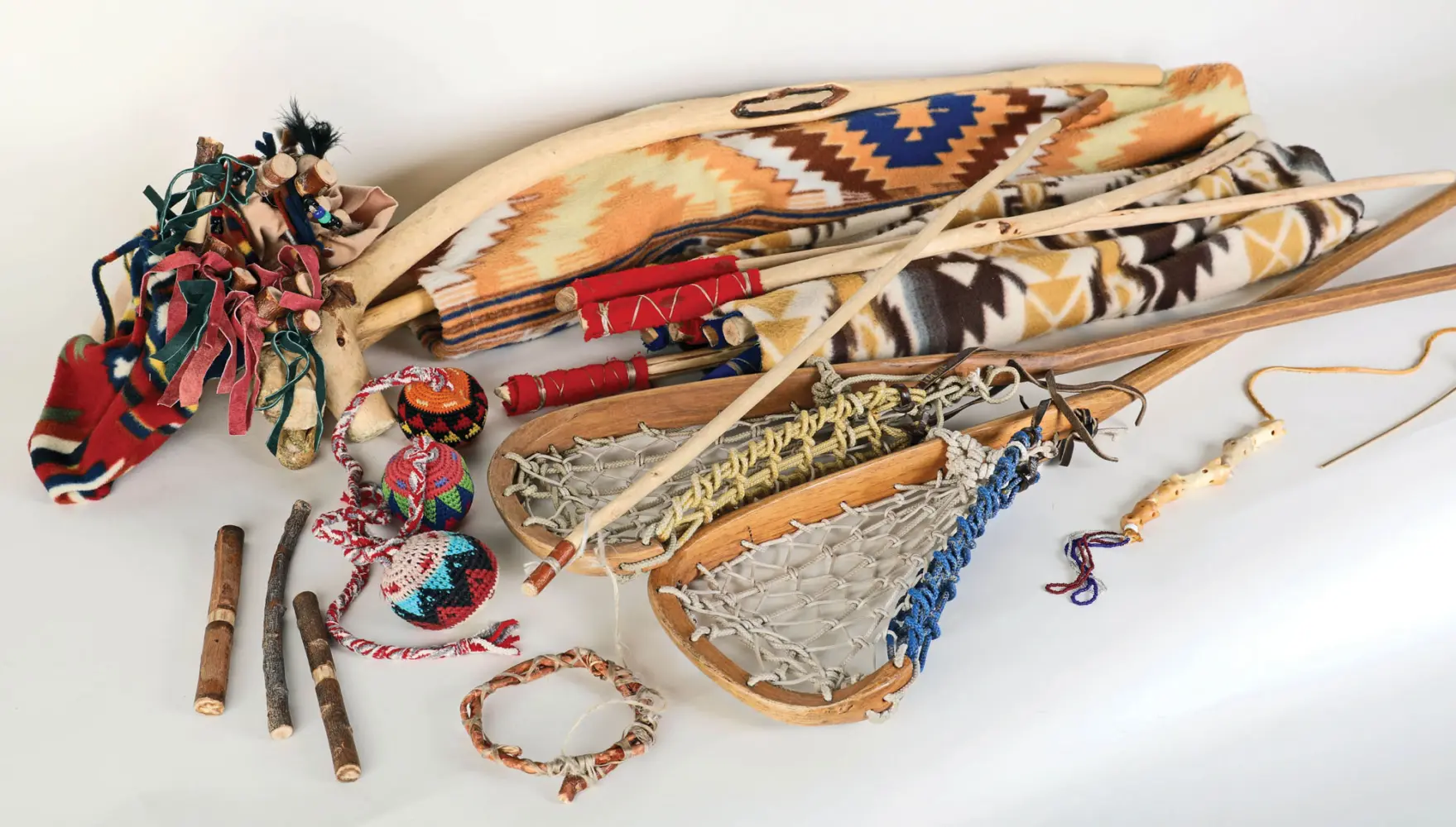 A display of Native American artifacts, including a beaded cradleboard, a dreamcatcher, and leather accessories.